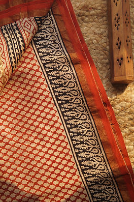 Artisan at a traditional pit loom weaving a cotton saree in afternoon light